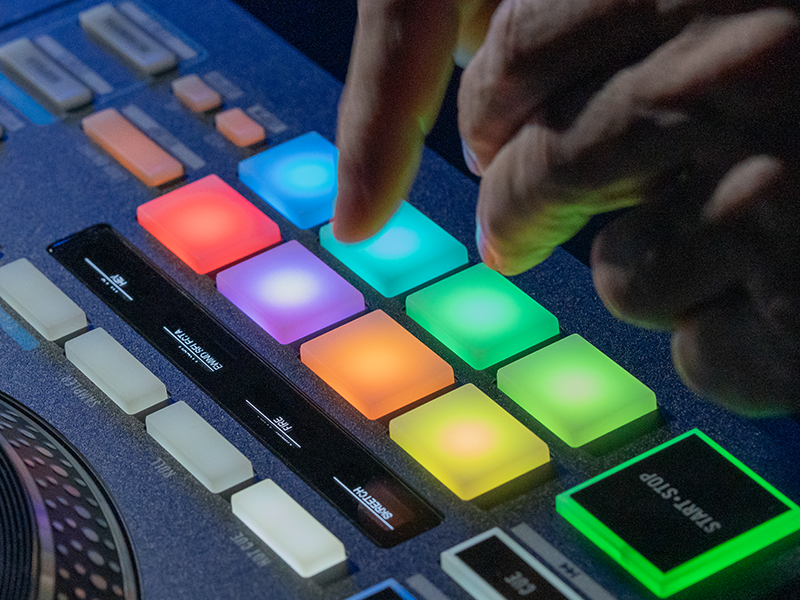 Close-up shots of colorful illuminated drum pad controller buttons being pressed. Shows various RGB lighting effects in different colors.
