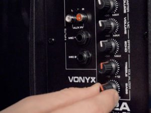 Text visible: 'VOXTRA'. Close-up of audio equipment control panel with multiple adjustment knobs and buttons in black finish.
