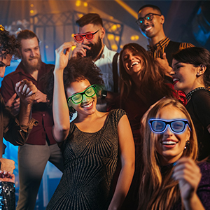 Group of people at a party wearing colorful accessories. Festive atmosphere with people smiling and enjoying themselves.