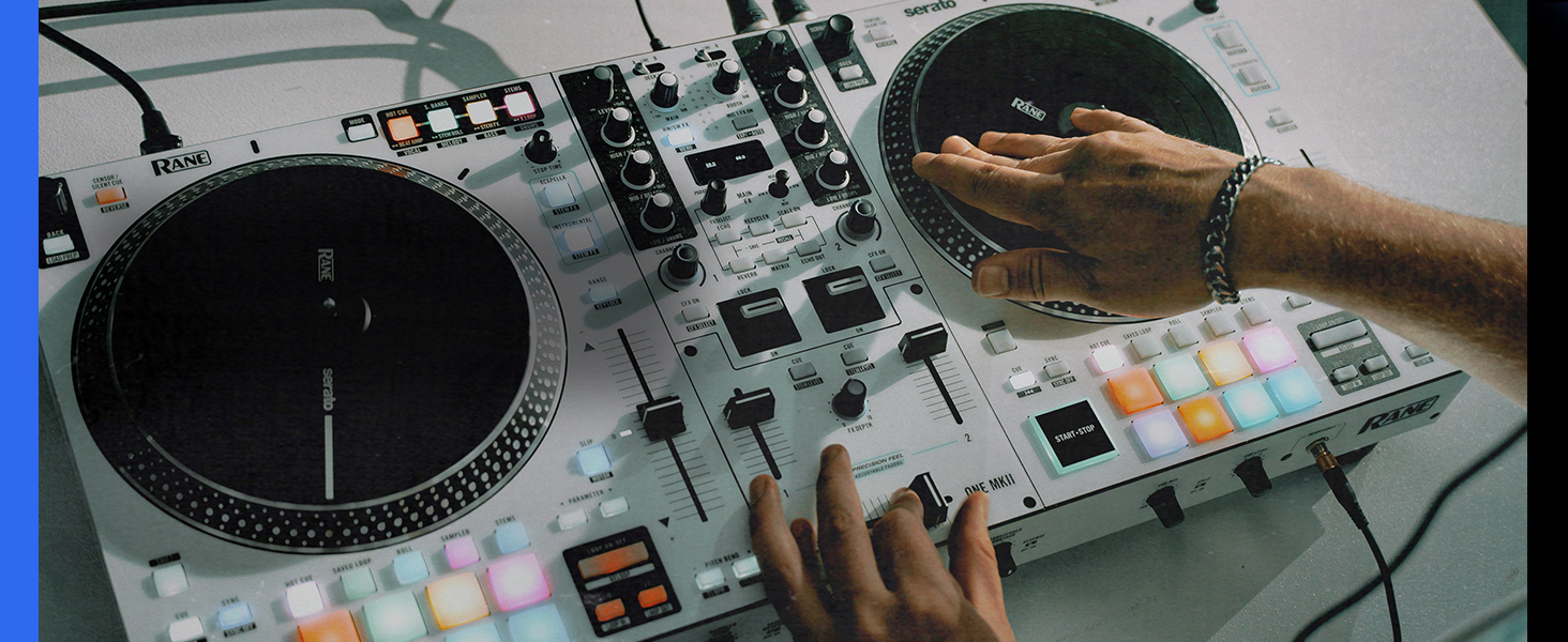 Professional DJ equipment setup showing turntables and mixer console with illuminated controls in dark setting.