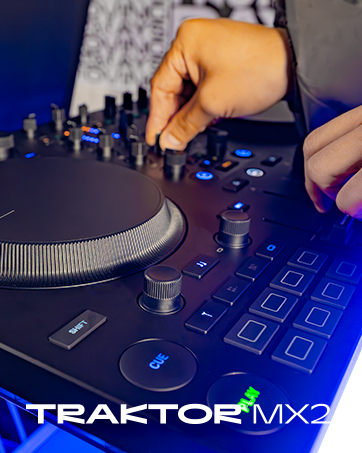 Text reads 'TRAKTOR MX3'. Hands operating a blue DJ mixing controller with illuminated buttons and touch-sensitive pad for music production and DJing.